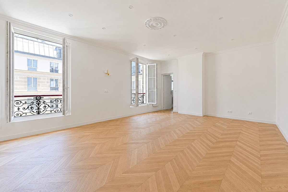 Le même séjour après travaux : parquet en point de Hongrie, rosace de plafond, fenêtres restaurées.